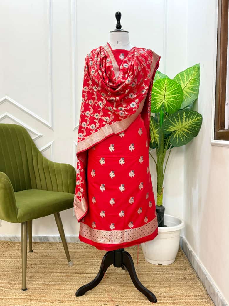 Red traditional outfit with a matching dupatta on a mannequin against a white wall.