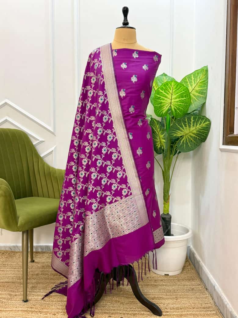 Purple floral saree on a mannequin with a green chair and plant in the background