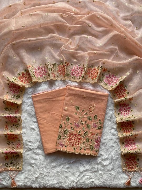 Pink embroidered fabric with floral patterns on a textured surface