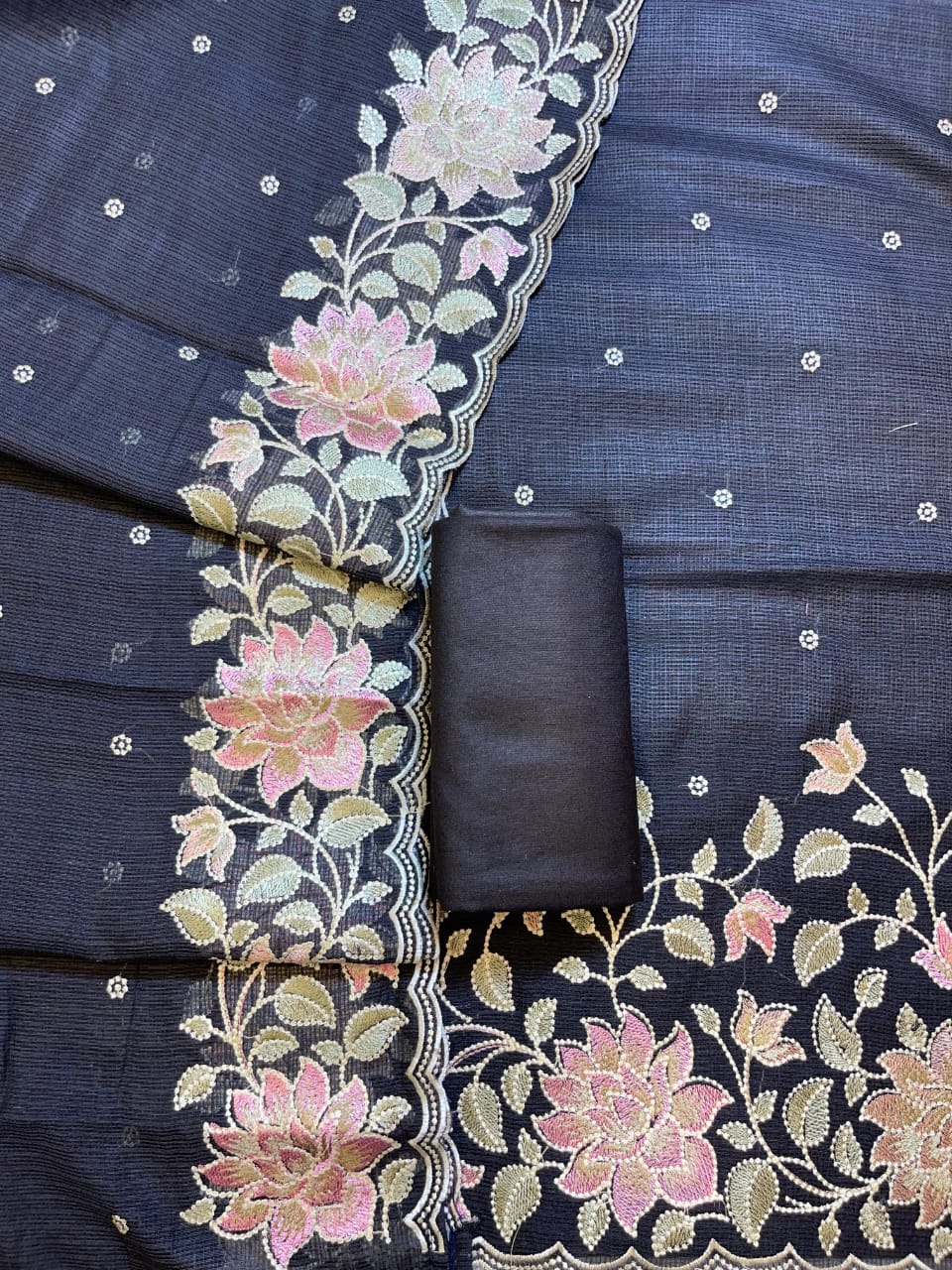 Navy blue fabric with floral embroidery and a folded black fabric