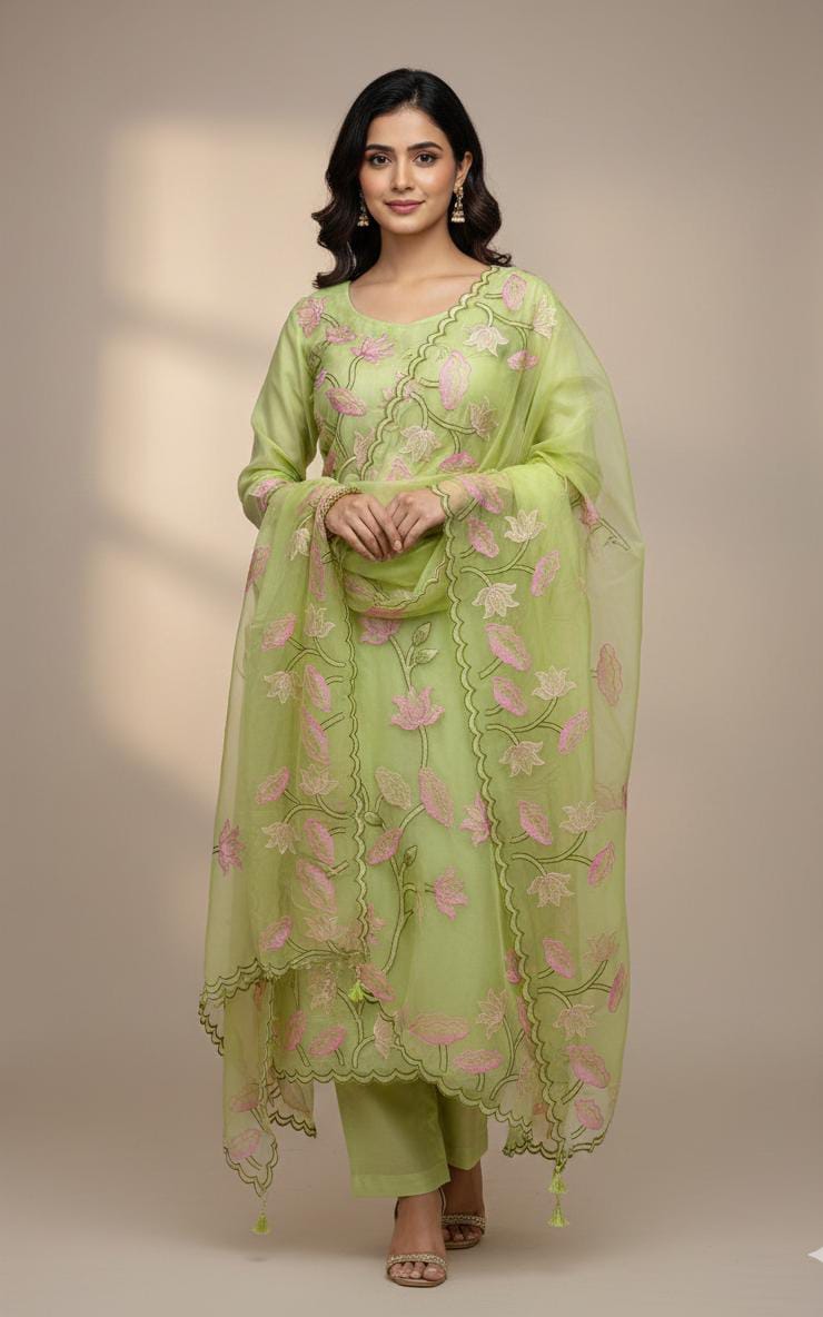 Woman wearing a light green embroidered traditional outfit on a beige background
