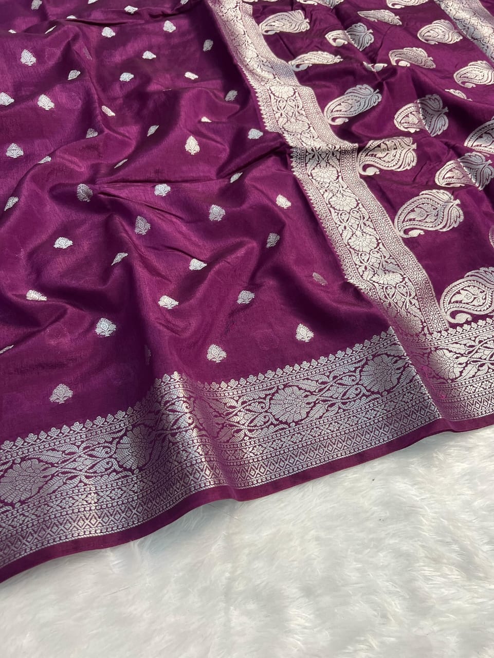 Purple fabric with silver embroidery on a white background