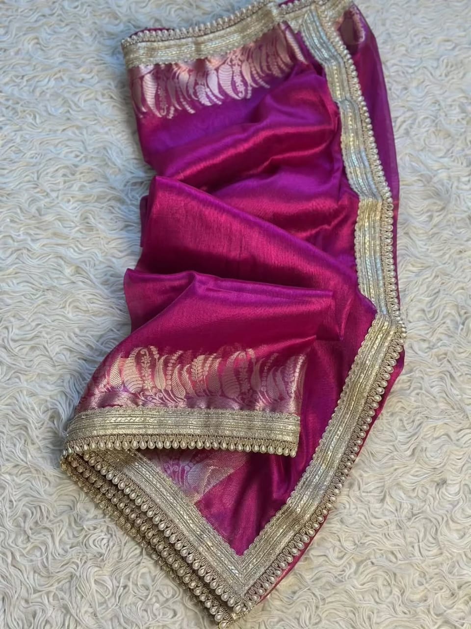 Purple saree with gold border on a textured light background