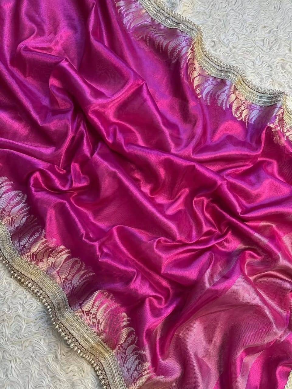 Pink fabric with gold embroidery on a textured background