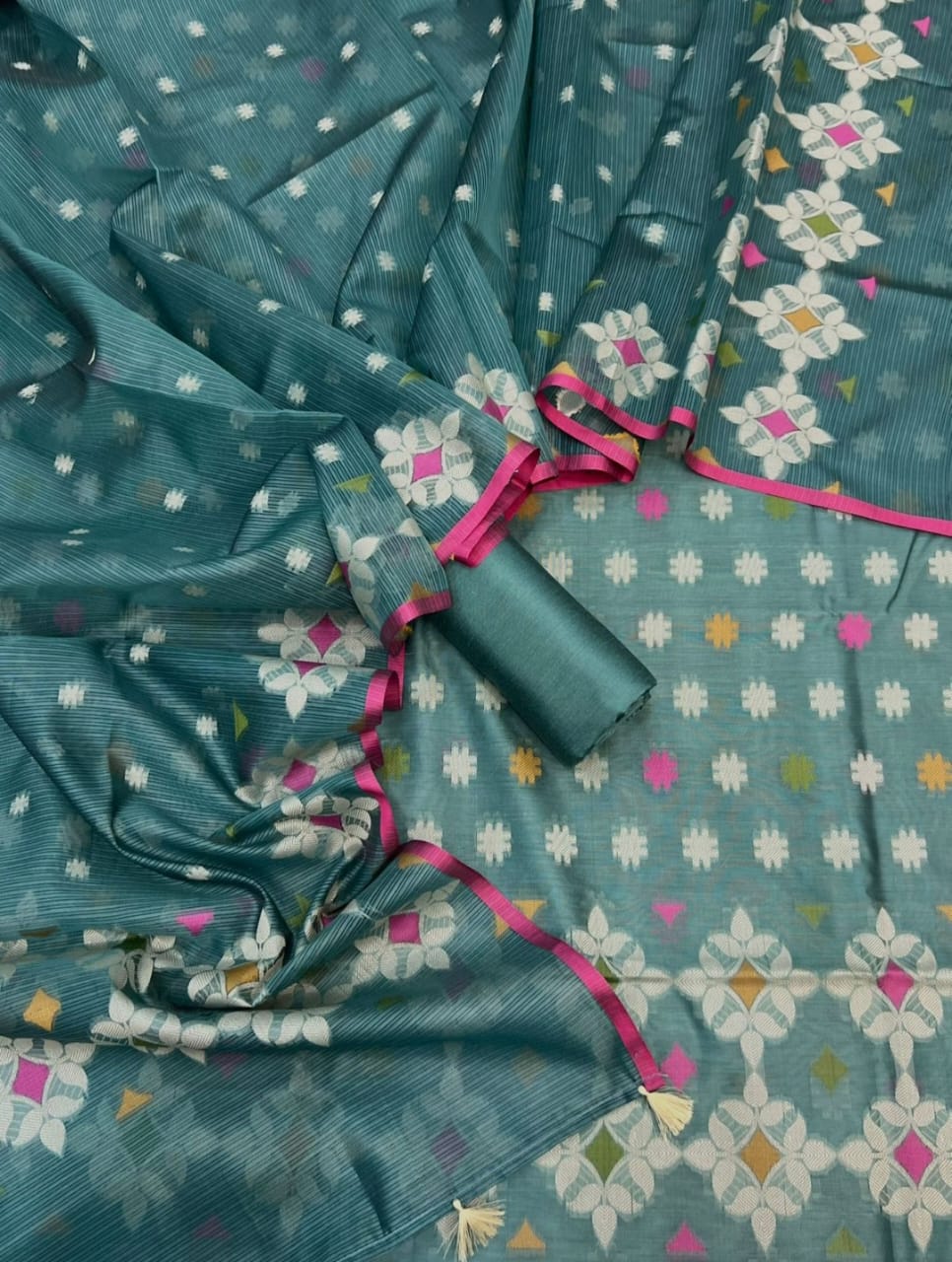 Teal fabric with white floral patterns and pink border