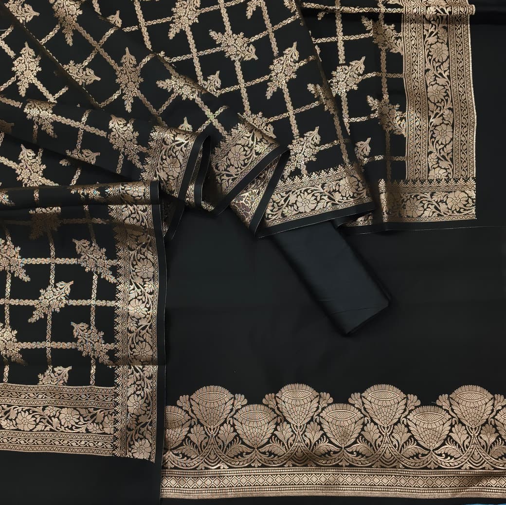 Black fabric with intricate gold embroidery on a dark background