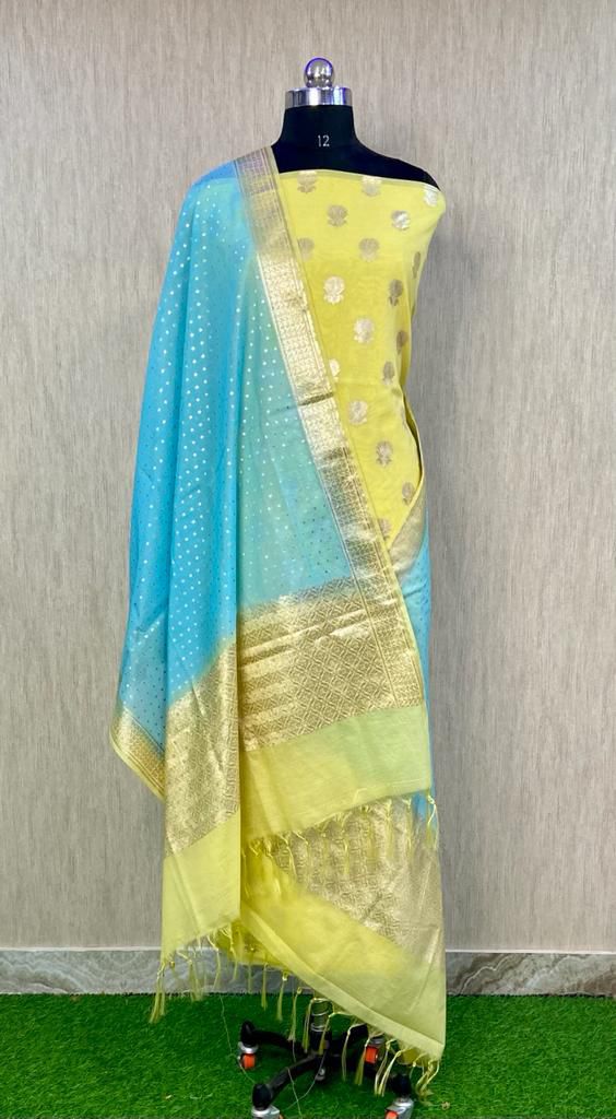 Yellow and blue saree with a gold border on a mannequin against a neutral background