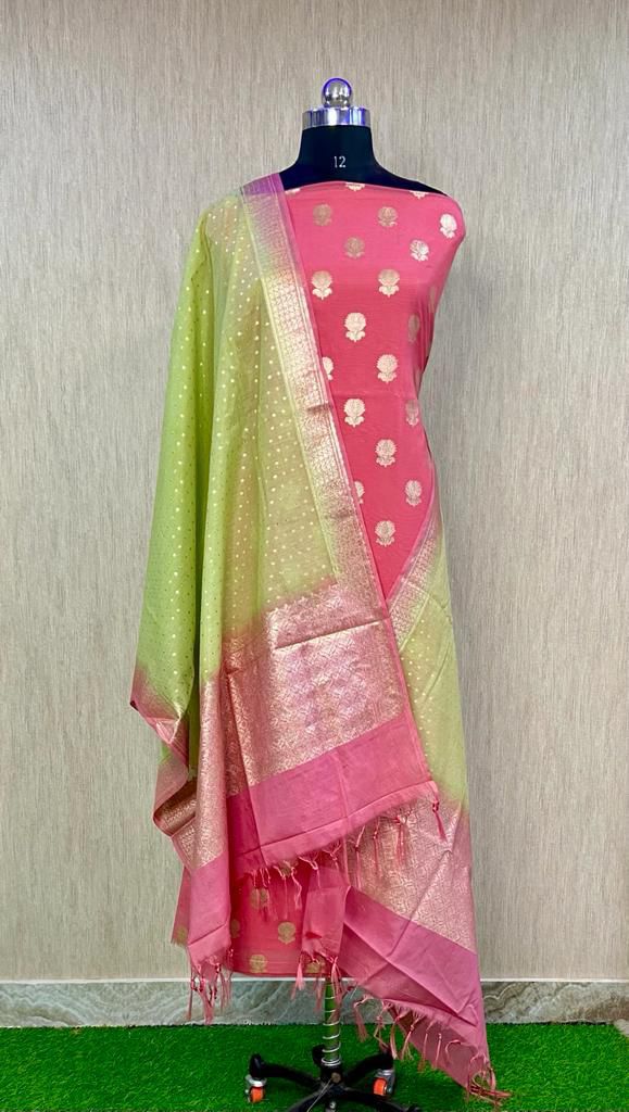 Mannequin wearing a pink and green saree with a subtle pattern on a neutral background