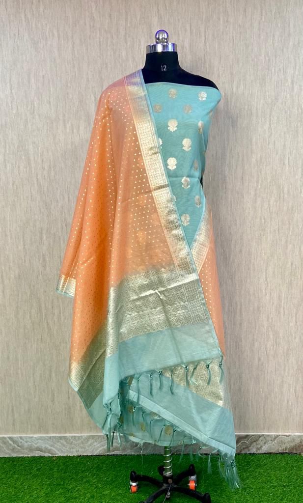 Teal saree with gold border on a mannequin against a neutral background