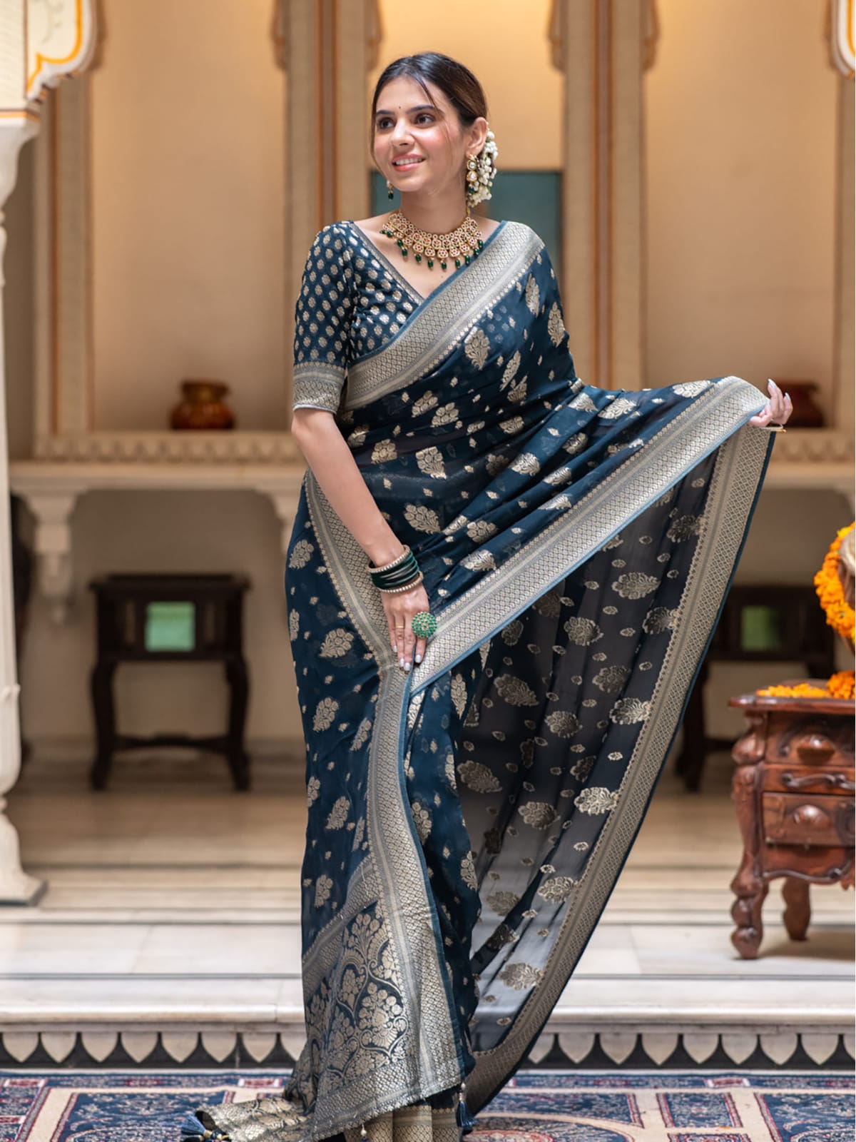 Woman in a blue saree with silver patterns indoors