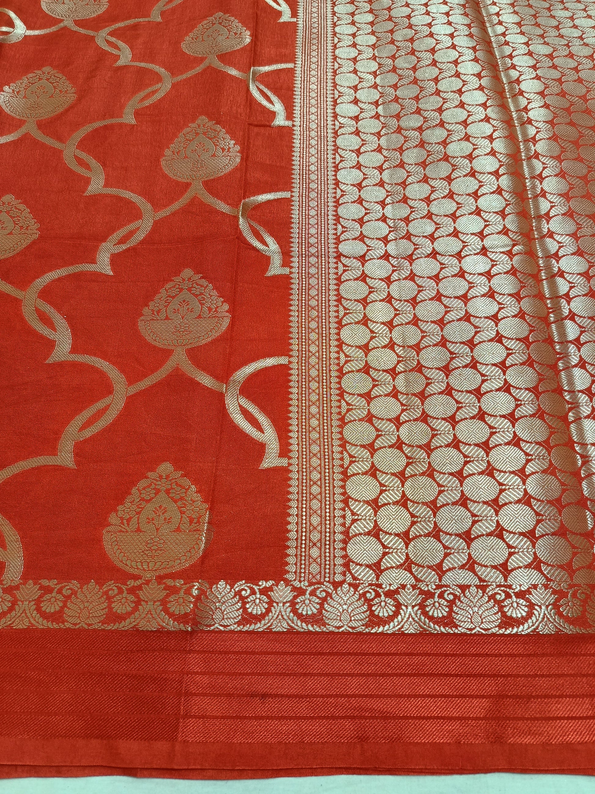 Red fabric with gold intricate patterns on a light blue background