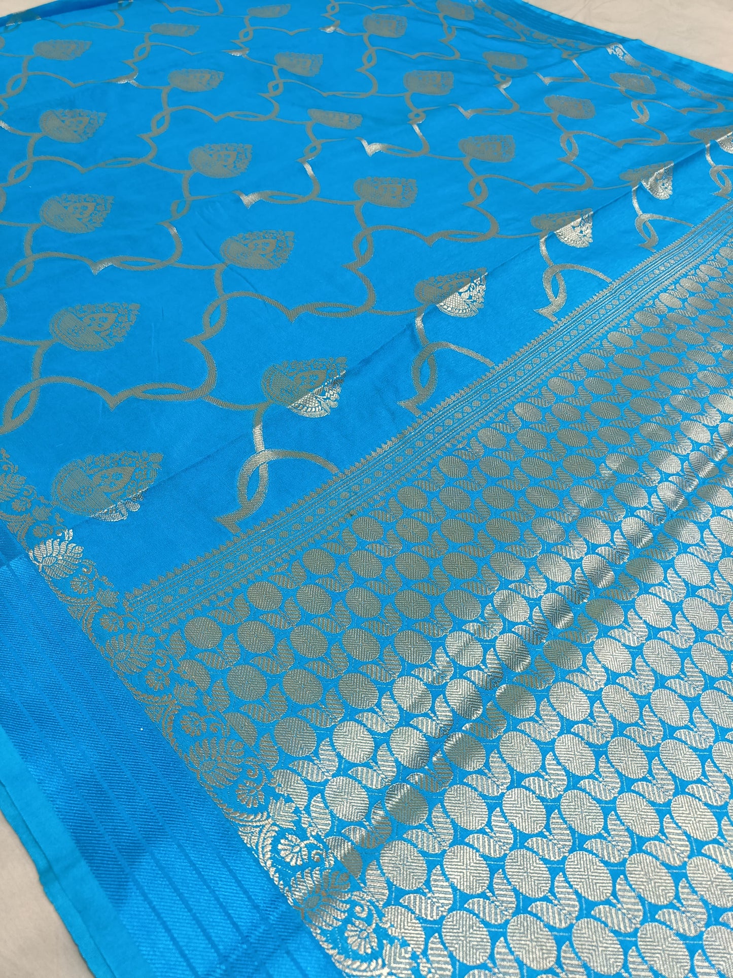 Blue saree with silver patterns on a plain background