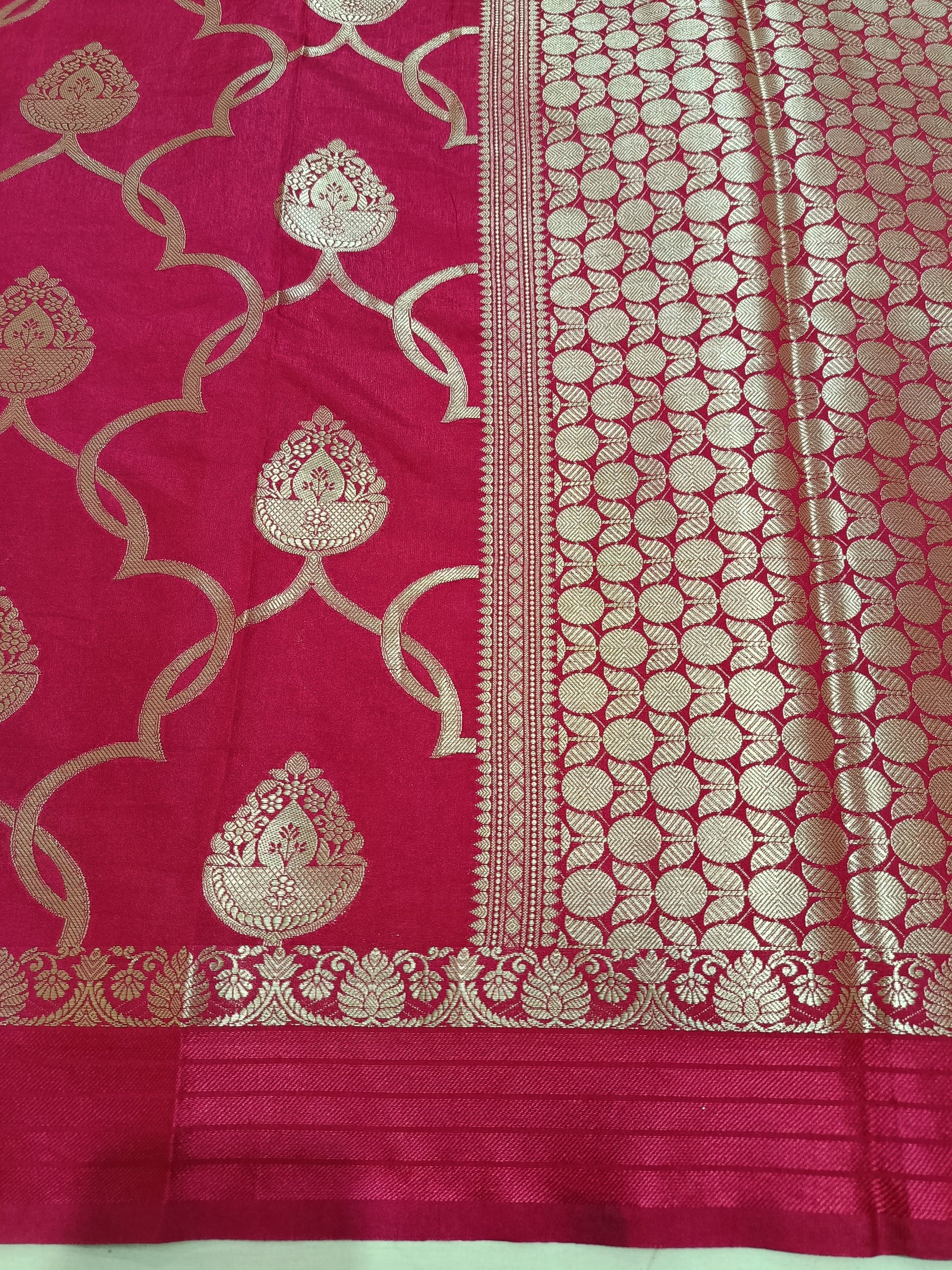 Pink saree with gold intricate patterns on a plain background
