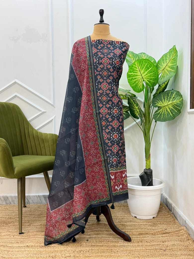 Traditional saree on a mannequin with a plant and chair in the background