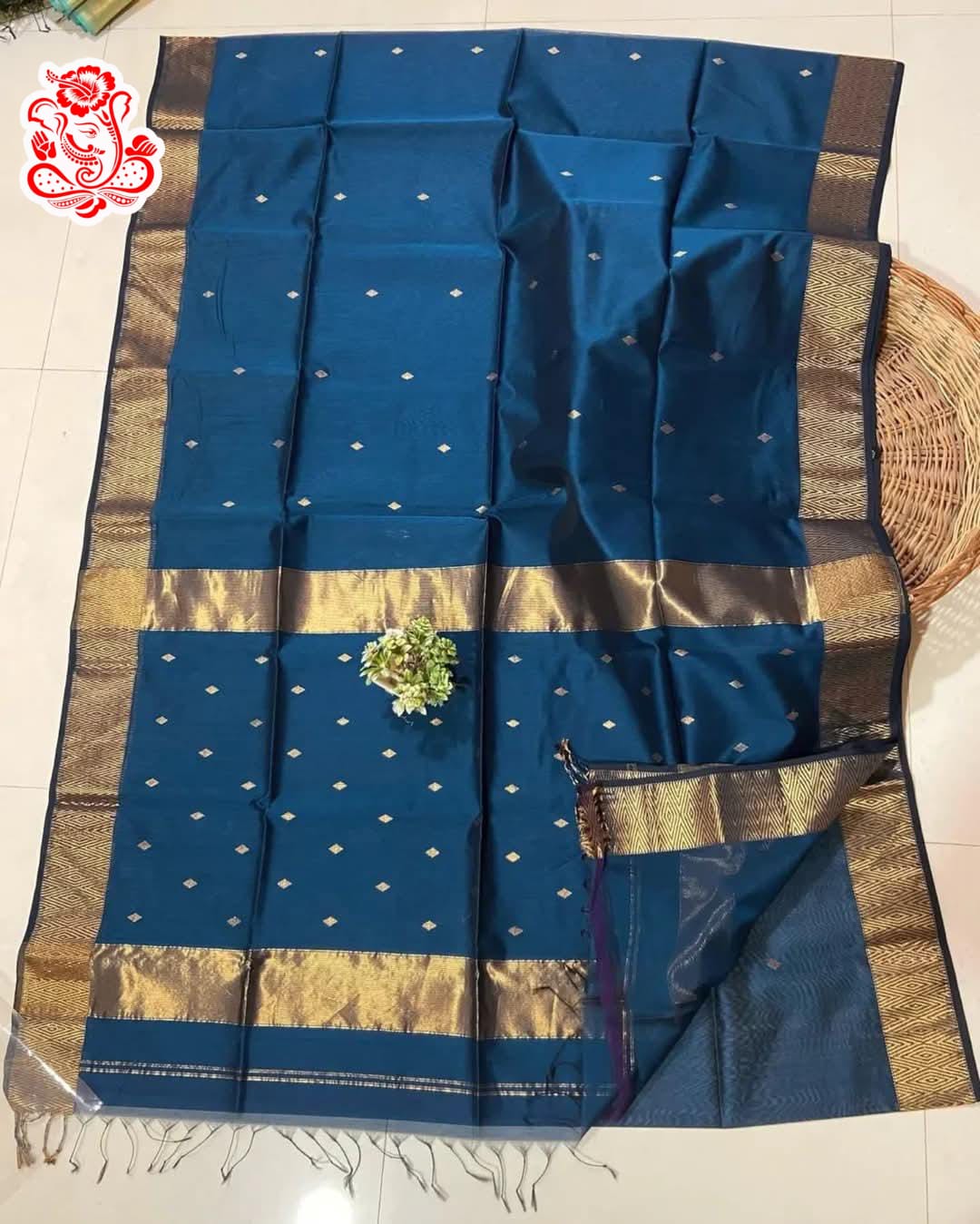 Blue saree with gold and brown patterns on a white surface