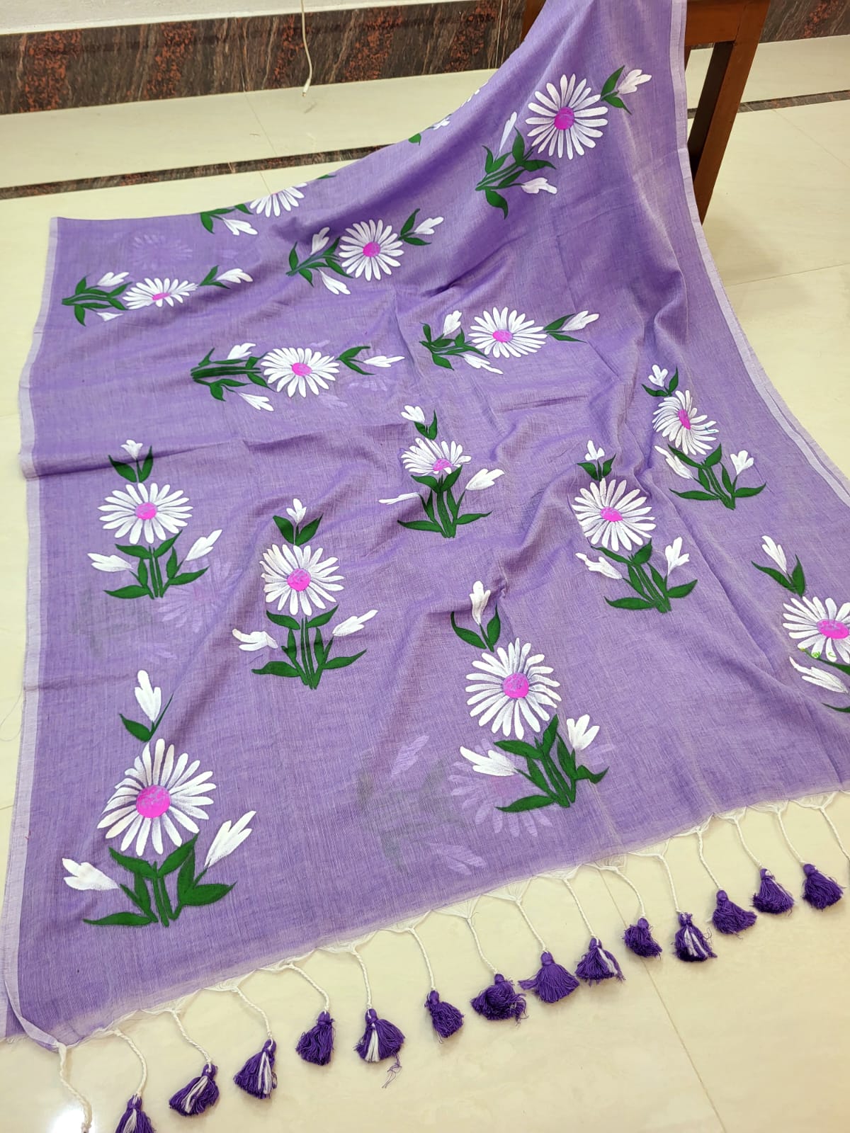 Purple scarf with floral patterns on a white surface