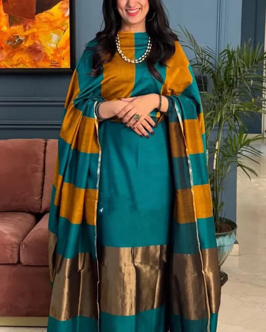 Woman wearing a teal and orange traditional outfit with a matching shawl indoors.