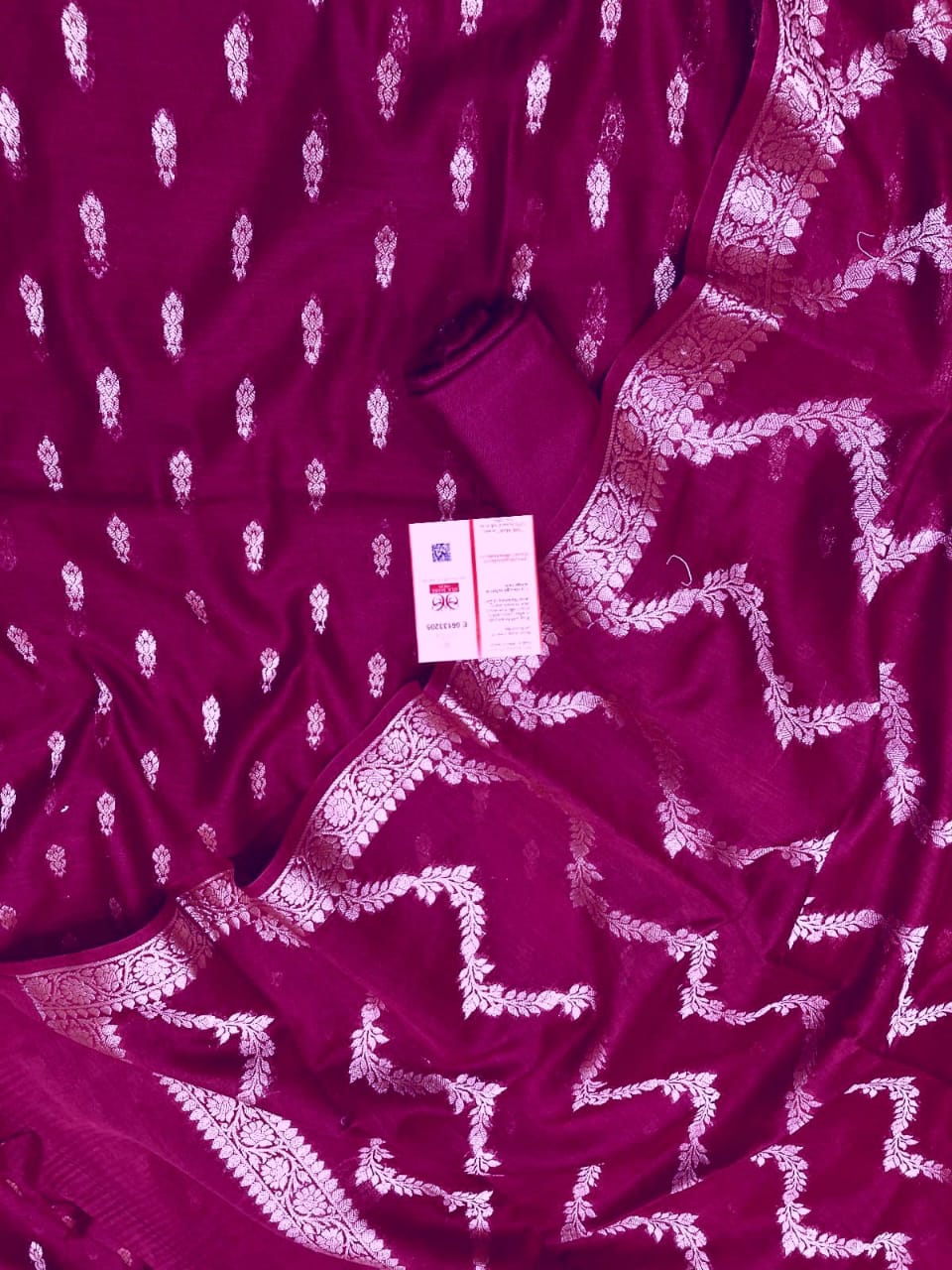 Purple fabric with white patterns and a visible tag on a matching purple background