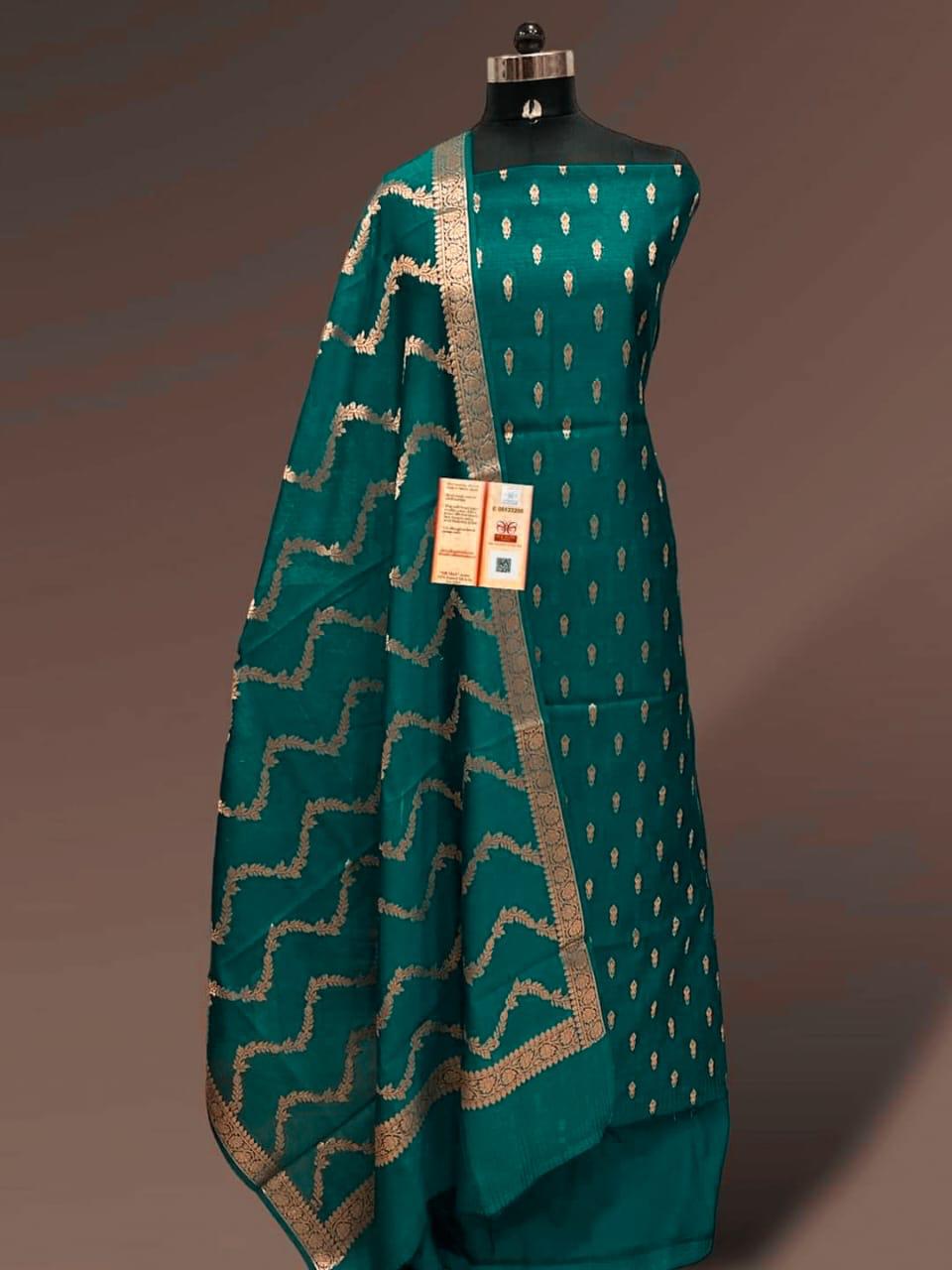 Teal saree with gold patterns on a mannequin against a brown background