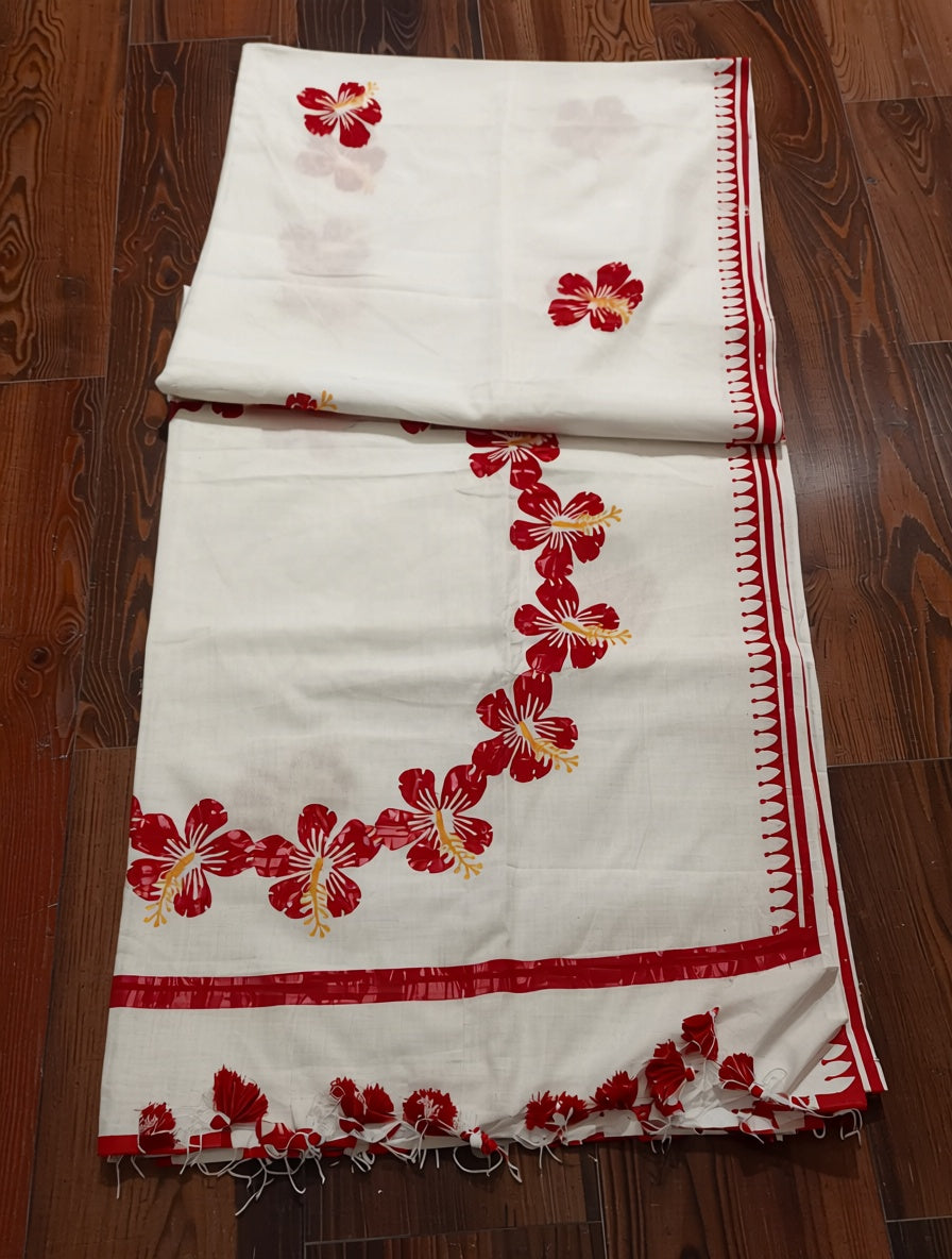 White fabric with red floral embroidery on a wooden floor