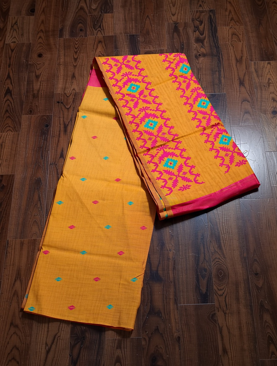 Yellow saree with pink and blue patterns on a wooden floor